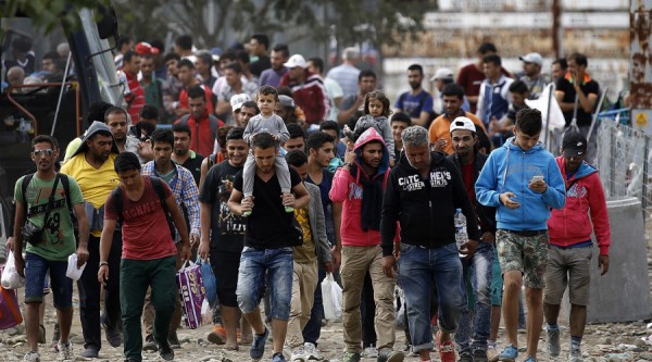 Syrian refugees walk towards Greece's border with Macedonia, moments before crossing near the Greek village of Idomeni