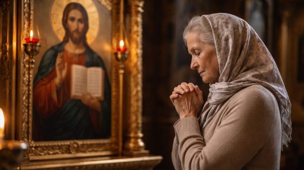 O femeie batrana se roaga in biserica in fata icoanei Mantuitorului.